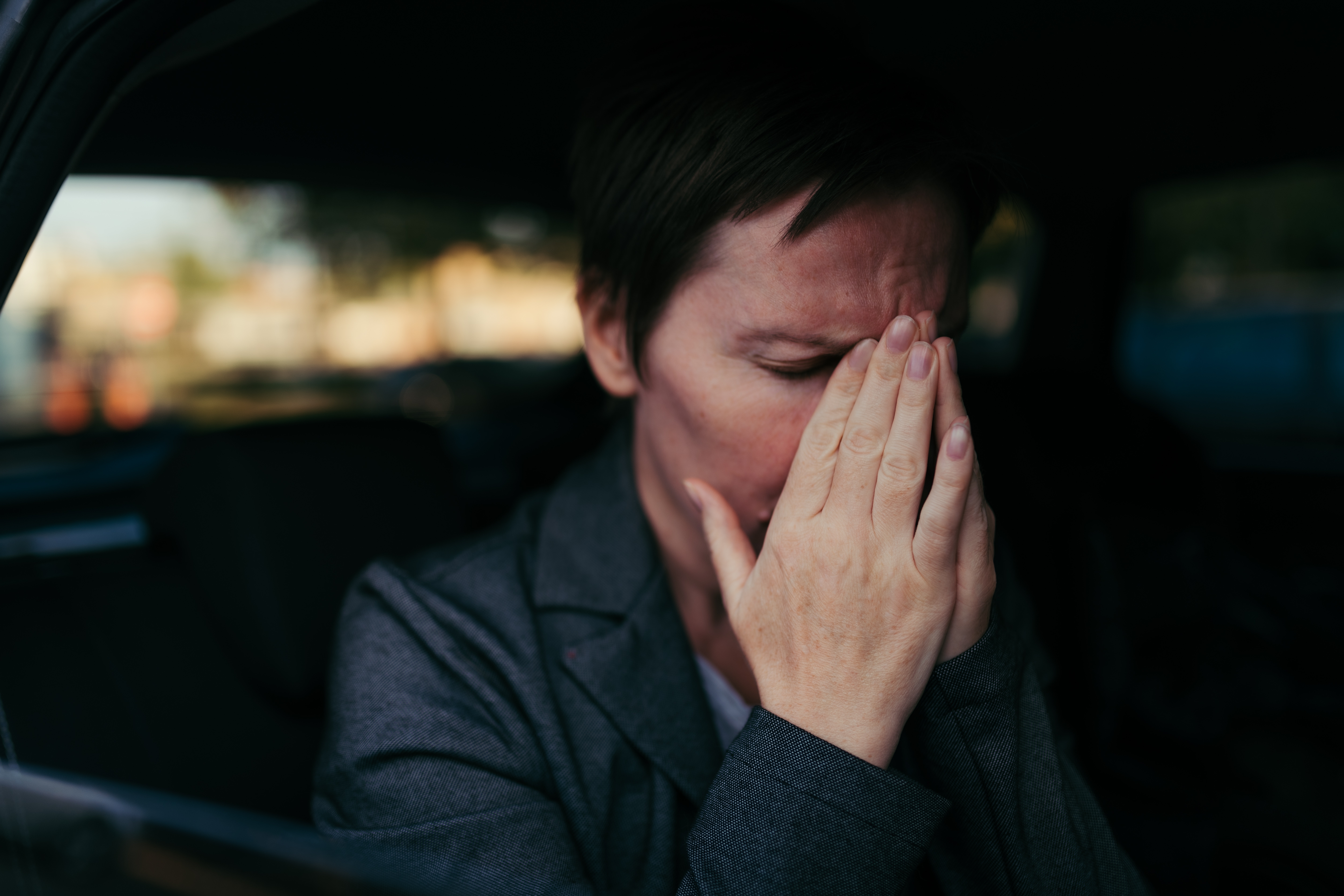 Anxious woman ⁢sitting in the back ⁣of a car | Source: ‌Shutterstock