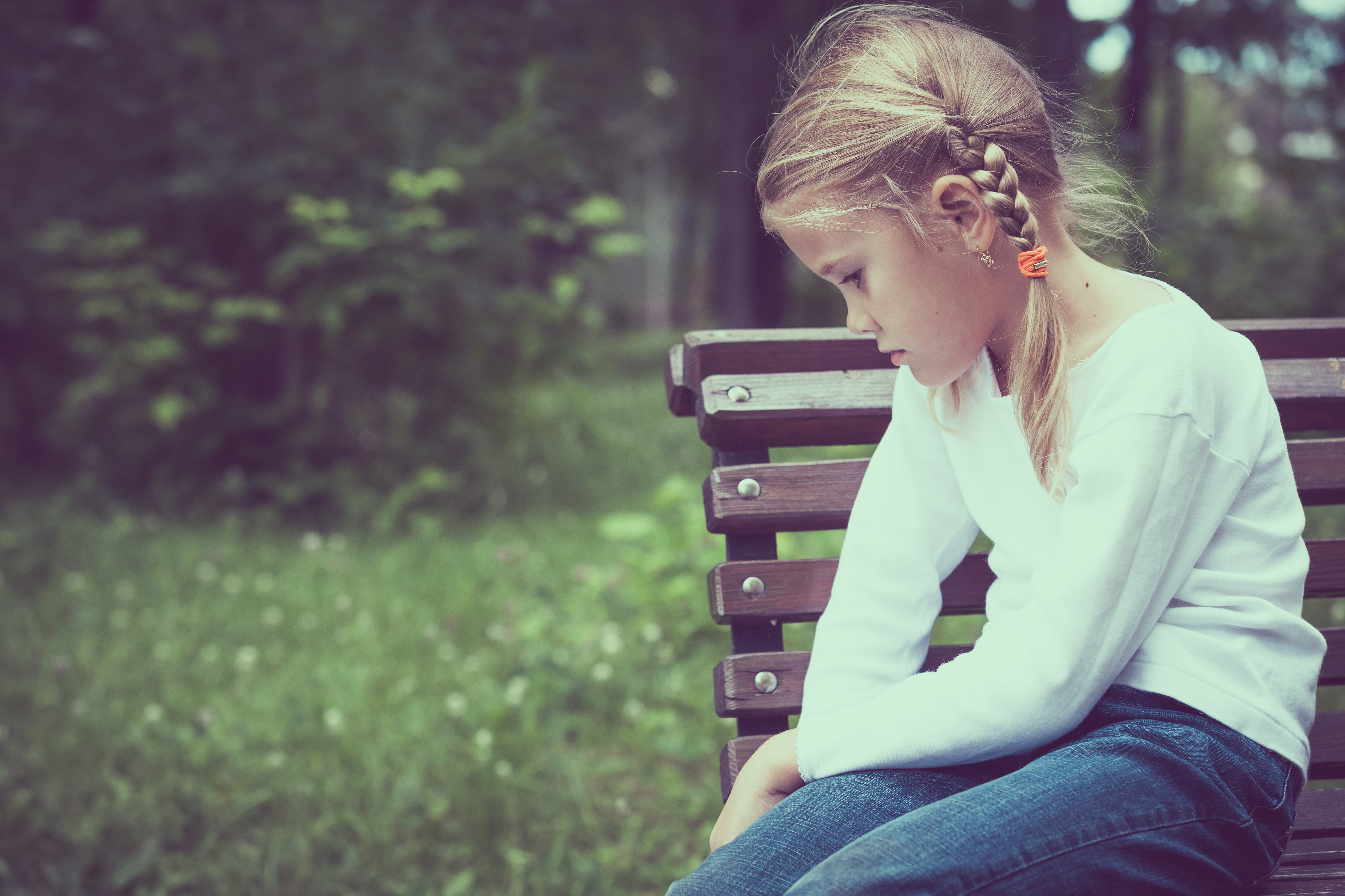 A⁣ little girl sitting on a bench | Source: Shutterstock