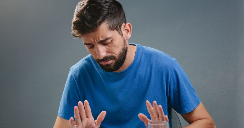 Portrait of man with no appetite in front of the meal. Concept of loss of appetite