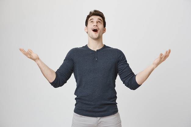 Relieved man thanking god, looking up sky grateful