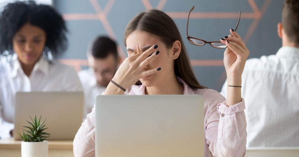 Young woman taking off glasses