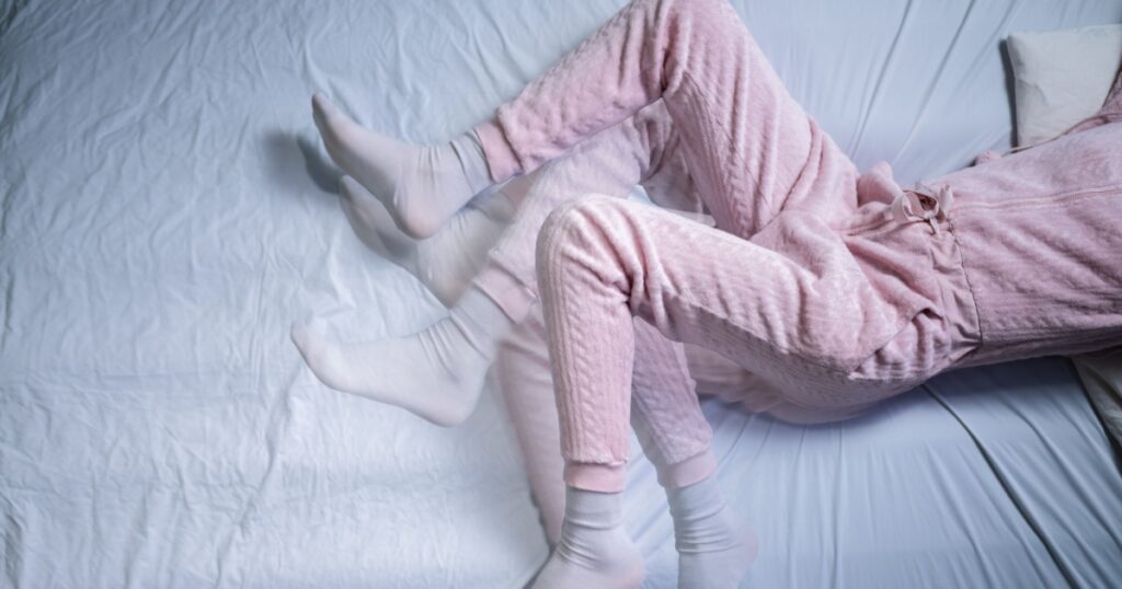 African American Woman With RLS - Restless Legs Syndrome. Sleeping In Bed